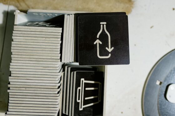 Close-up of durable plywood material used for manufacturing recycling bins, showing high-quality wooden layers and engraved waste sorting symbols.