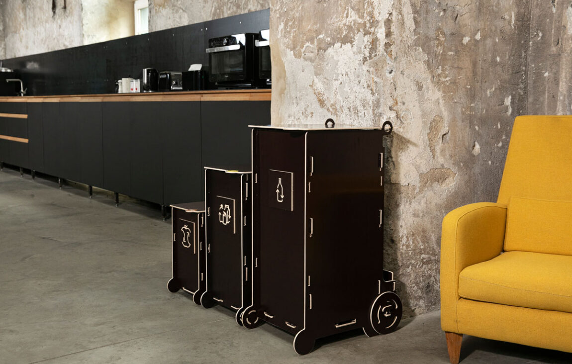 Modern dark-toned waste bins for sustainable living, featuring separate sections for glass, paper, packaging, and bio waste in a stylish interior.
