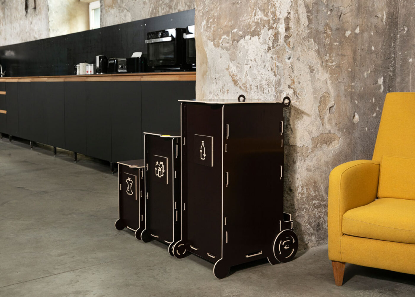 Modern dark-toned waste bins for sustainable living, featuring separate sections for glass, paper, packaging, and bio waste in a stylish interior.