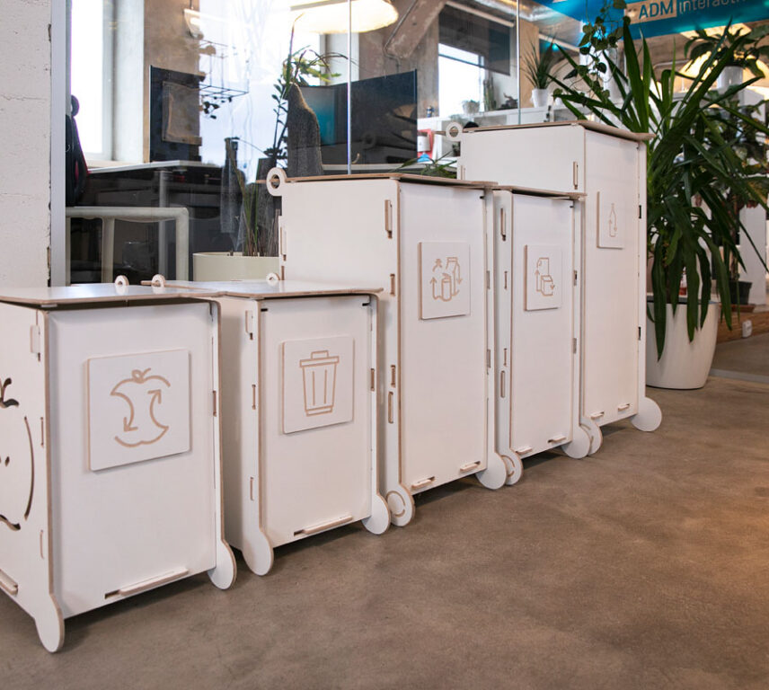 Modern white waste bins with lids and wheels, ideal for offices or public interiors, featuring separate sections for paper, packaging, and bio waste.