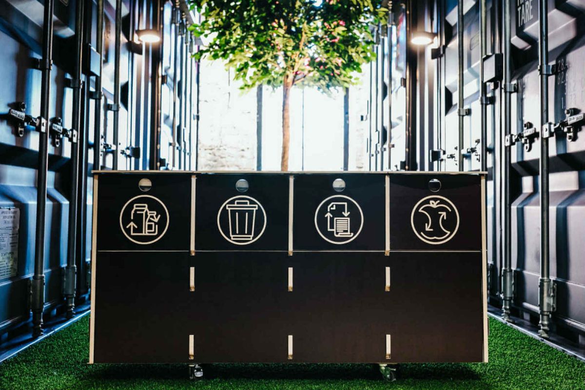 Eco-friendly wooden waste bin compared to metal and plastic alternatives in sustainable waste management.