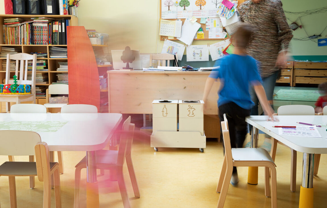 Recycling bins for indoor activity areas placed near exits to support discreet waste sorting.
