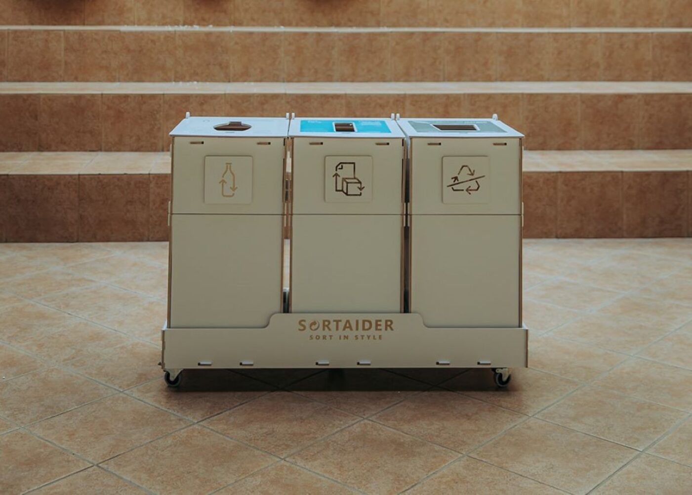 Recycling bins with instructional stickers helping staff sort materials correctly in an office.