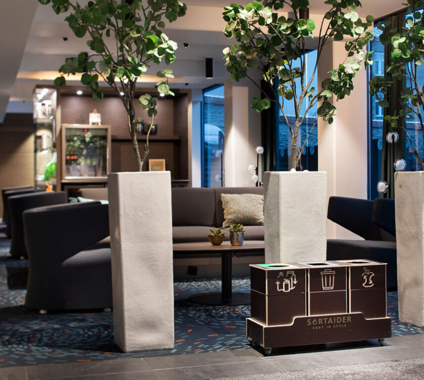 Recycling bins for sustainable offices placed in a shared workspace to make waste sorting feel effortless.