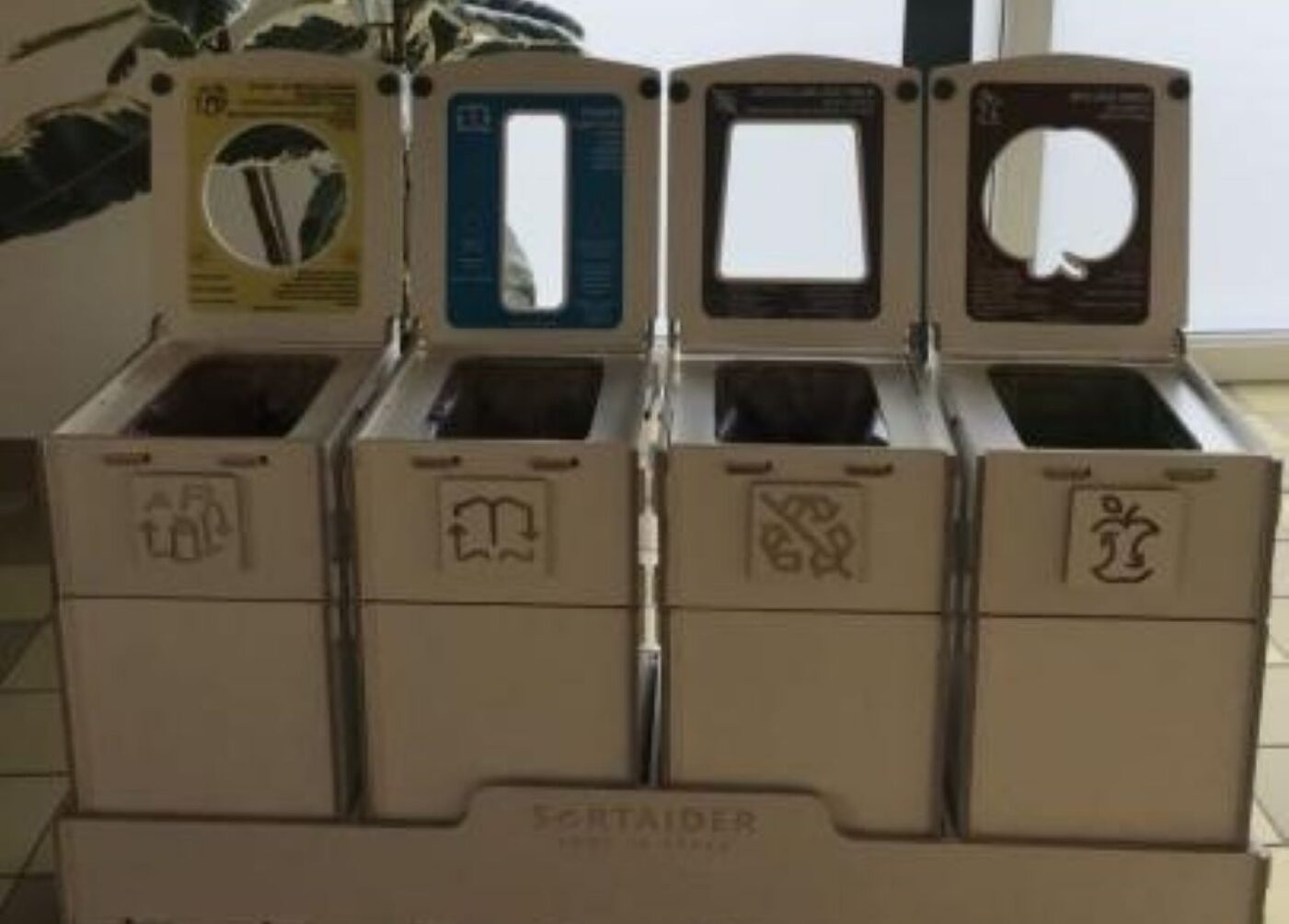 Affaldssorteringsstationer og affaldssorteringsstationer med fire sektioner i klasseværelserne, der er designet til at hjælpe børnene med at sortere bioaffald, papir, emballage og almindeligt affald.
