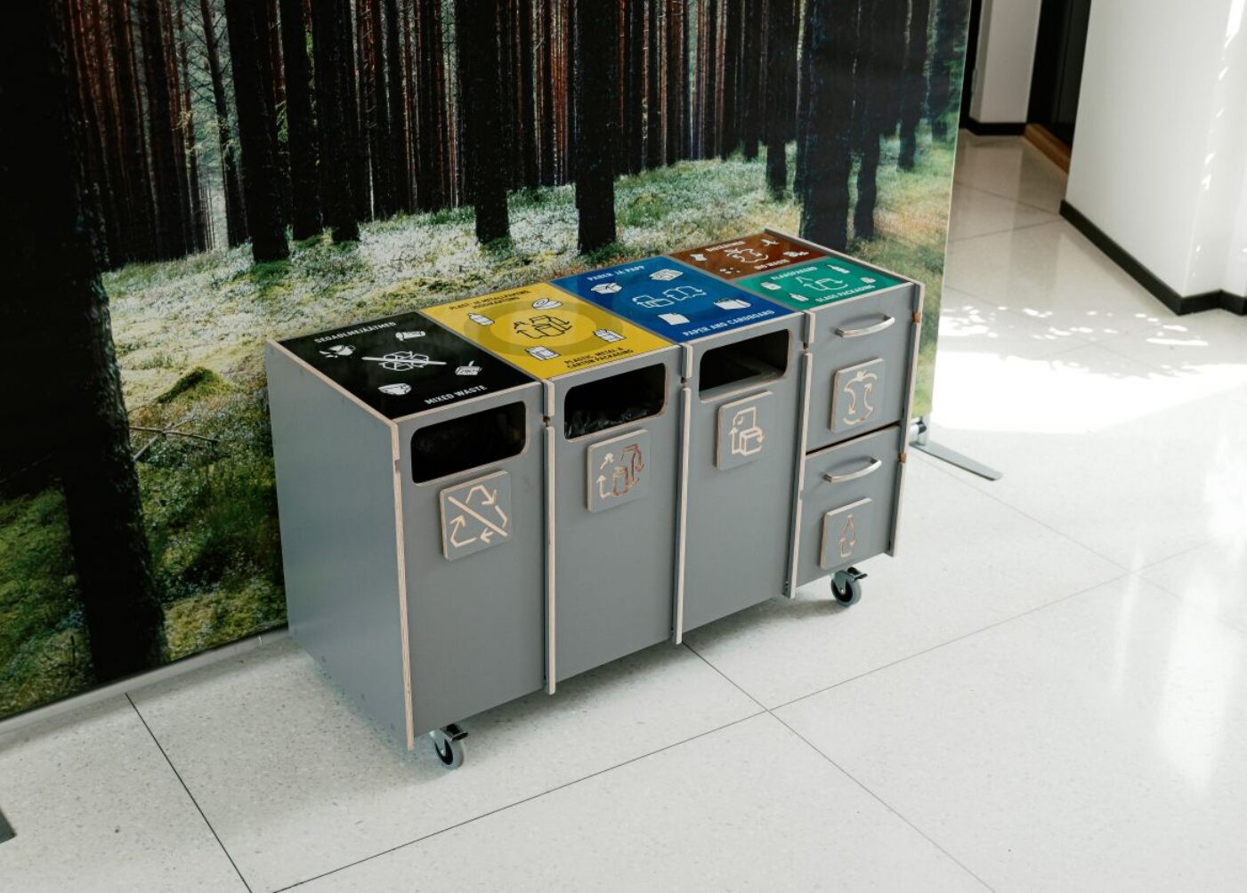 Affaldssorteringsstationer til universiteter og højere læreanstalter med mærkede rum til blandet affald, plast, papir og bioaffald.