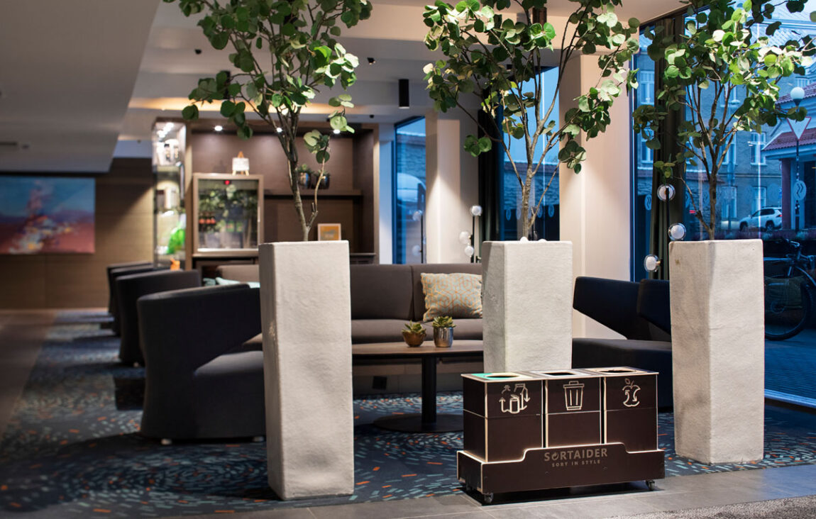 Källsortering för hållbara kontor placerade i en gemensam arbetsmiljö för att göra avfallssorteringen enkel.