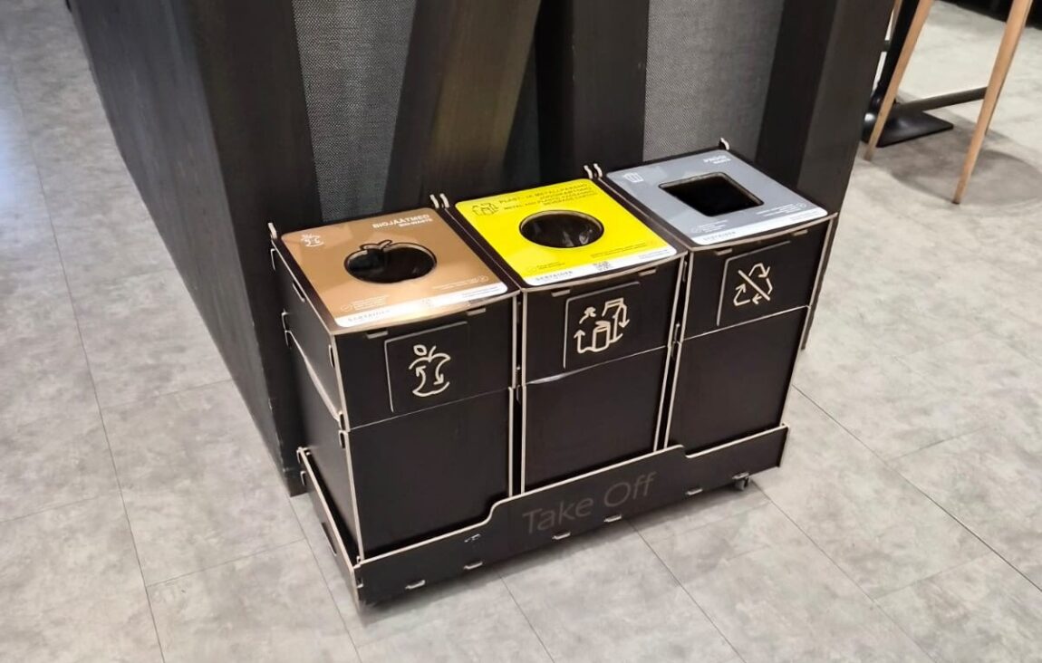 Källsortering för kontorsköksutrymmen placerade nära bänkar för att underlätta sortering av mat- och förpackningsavfall.