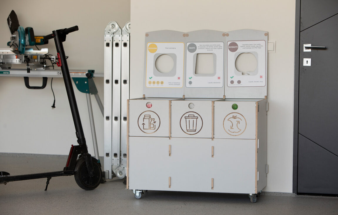 Källsortering för kontorsförrådsutrymmen placerade nära förvaringshyllor för att underlätta återvinning av förpackningar.