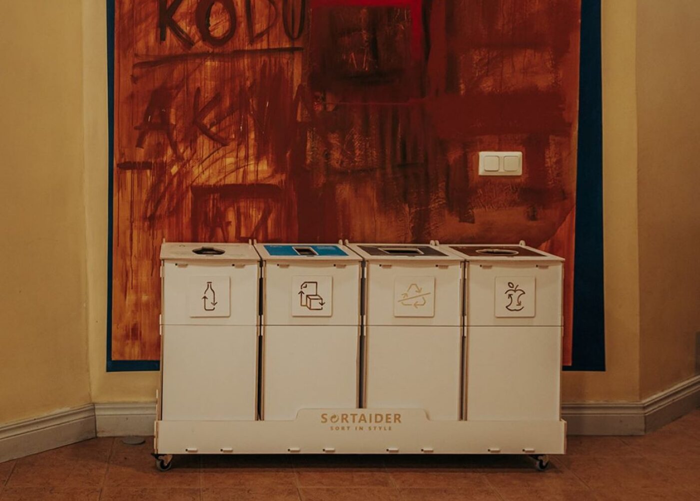 Källsortering med lock i ett gemensamt inomhusutrymme för att minska lukt och hålla sorteringsutrymmena snygga.