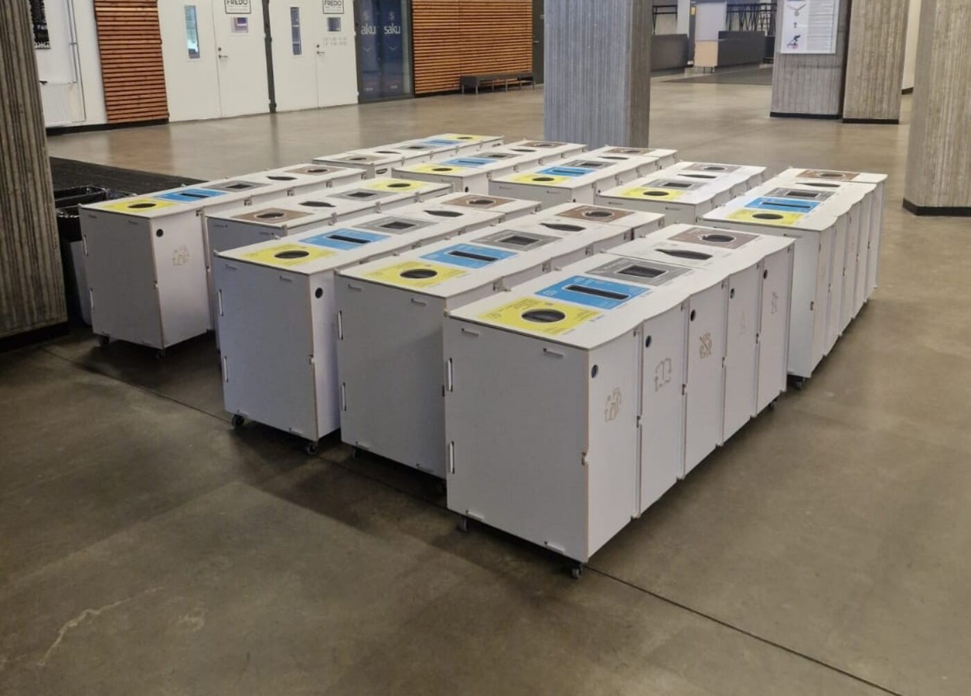 Papperskorgar för kontorscirkulationsnav placerade i högtrafikerade områden för att underlätta snabb Källsortering.