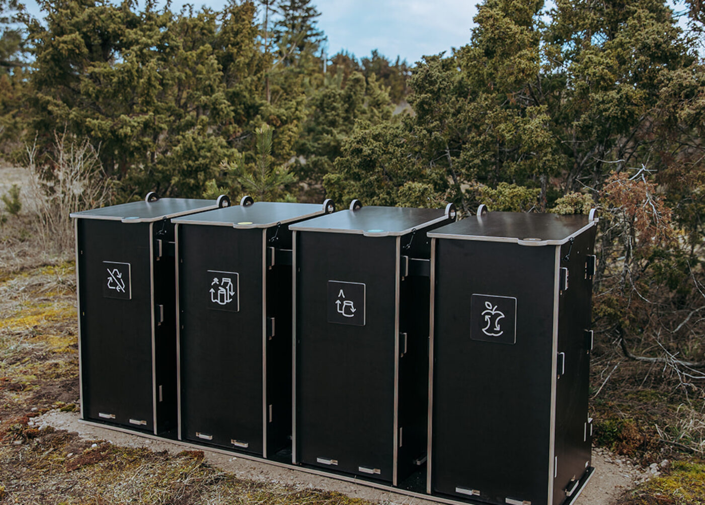 Hållbara Papperskorgar för utomhusbruk med flera fack för sortering av glas, papper, förpackningar och bioavfall i offentliga utrymmen.