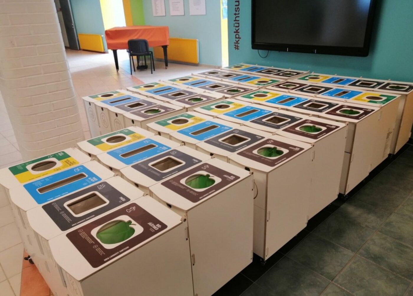 Row of modular waste sorting bins for office recycling including paper, packaging, and bio-waste.